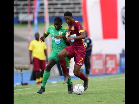 Dinthill’s Karim Bryan (right) is challenged by Excelsior’s Aseany Richards in their ISSA Champions Cup match-up at the National Stadium recently. 