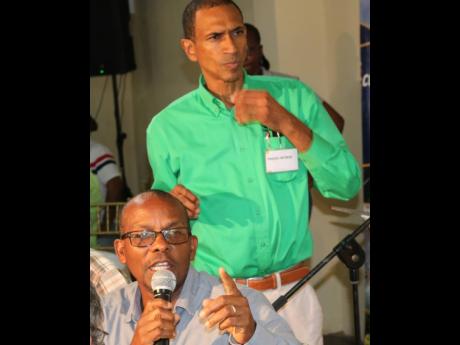 CEO of the Sugar Industry Authority, George Callaghan, answering questions at the annual general meeting of the All-Island Jamaica Cane Farmers Association yesterday, while manager Nigel Myrie listens. Photo by Christopher Serju