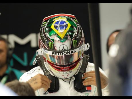 Mercedes driver Lewis Hamilton, of Britain, wears a helmet designed with an image of  Brazil’s national flag during the first free practice at the Interlagos racetrack in Sao Paulo, Brazil, yesterday.