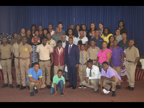 Pastor Errol Rattray (standing in the centre of the second row), president and chief executive officer of the Errol Rattray Evangelistic Association, is surrounded by scholarship recipients, their relatives, guidance counsellors, and representatives of the Ministry of Education.