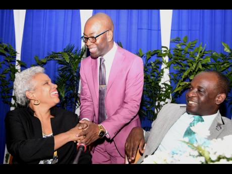 Owen Speid (centre), president of Jamaica Teachers’ Association (JTA), greets guest speaker Margaret Campbell, principal of St George’s College and LASCO Principal of the Year, and Jasford Gabriel, president-elect of the JTA, at the JTA’s Educational Symposium at the Jamaica Conference Centre in downtown Kingston on Monday.