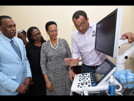 Dr Christopher Tufton (right), minister of health and wellness; Dr Camille Christian (second right), head of the Cardiology Unit at Kingston Public Hospital; Billy Heaven (left), CEO of the CHASE Fund, and Katherine Cooper Brown, acting CEO of KPH, view the technology on offer at the official opening of the Cardiology Department at KPH on Wednesday. Rudolph Brown/Photographer
