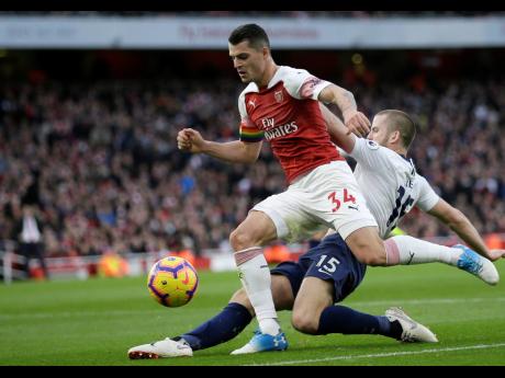 Arsenal’s Granit Xhaka (left) fights for the ball with Tottenham’s Eric Dier during their north London derby in the English Premier League at the Emirates Stadium.