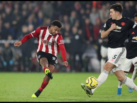 Sheffield United’s Lys Mousset (left) scores his side’s second goal during their English Premier League match against Manchester United at Bramall Lane Stadium in Sheffield, England, yesterday.