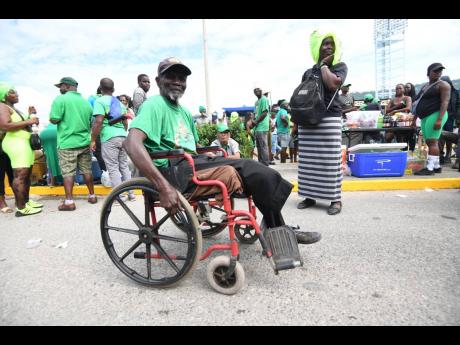 Leaford Fairclough, 75, a resident of the Golden Age Home, wheels himself towards the National Arena to participate in the festivities of the JLP’s conference yesterday. Fairclough pushed himself approximately 3.5km to the venue. 