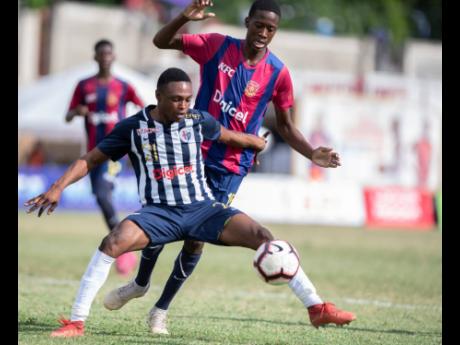 Garrington Baker of Jamaica College (foreground) defends against Sekani Campbell of St Andrew Technical (STATHS) in their ISSA/Digicel Manning Cup quarter-final fixture at Stadium East on Tuesday, November 12, 2019. STATHS won 2-1.