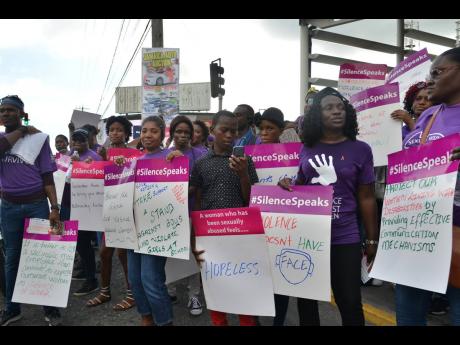 Campaigners gather on the sidewalk outside the Half-Way Tree Transport Centre in St Andrew on Monday as they stage a silent protest against gender-based violence.
