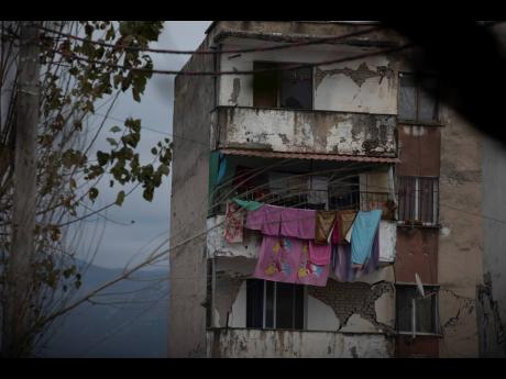 Laundry hangs on a line from a damaged building in Thumane, western Albania, following a deadly earthquake. 