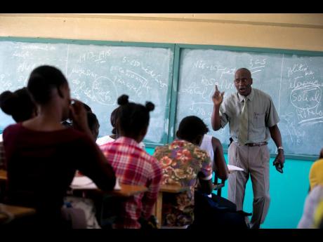 Students listen to school director Jean-Marc Charles at the Lycée school, which reopened about a week earlier than other schools in Petion-Ville, Haiti, on Thursday, November 28, 2019. Some Haitian children have begun to return to school after classes halted during months of violent unrest. 