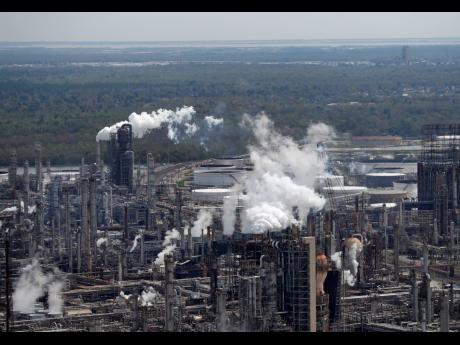 In this March 8, 2018 file photo, wetlands are seen beyond the Shell Norco refinery in Norco, La. The world may be heading into an oversupply of oil, and that possibility is hanging over members of the OPEC cartel.