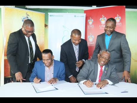 Jamaica Cricket Association (JCA) President Wilford ‘Billy’ Heaven (second left) and UWI Mona Principal Prof. Dale Webber (second right) sign a memorandum of understanding between the organisations at the Faculty of Sport at the UWI. Witnessing are (from left) JCA CEO Courtney Francis, UWI, Mona campus lawyer Carl Lawrence, and JCA’s Business Development Manager, Garth Williams.