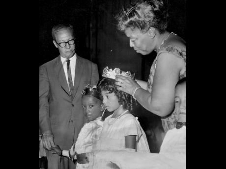 Una Marson, founder of the Jamaica Save the Children Foundation, crowns May Queen Debra Lyn Keisse at the Children’s concert held at the Ward Theatre on May 5, 1964. The May King, Horace Mesquita, is wearing his crown, which was presented by the deputy mayor, Councillor Wesley Shirley (left). 