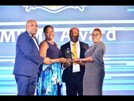 From left: Enock Gooden, Francene Gooden, and Conroy Ghans of Lifecall Ambulance accept the Micro Small & Medium Enterprises Award from director of the Montego Bay Chamber of Commerce Julian Palmer.