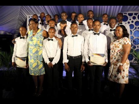 Welfare officers Ina Lawrence (second left) and Beverly Lawrence (right) with graduating class of apprentices for 2019 at a recent ceremony held at the Jamaica Racing Commission in Half Way Tree, St Andrew.