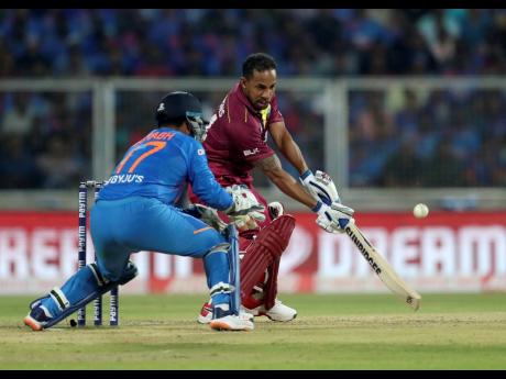 Windies’ Lendl Simmons (right) plays a shot on his way to his first half-century in nearly four years during the second Twenty20 International cricket match against India in Thiruvanathapuram, India, yesterday.