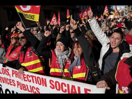 CGT Union protesters cheer at a march during a mass strike in Marseille, southern France, Tuesday, December 10, 2019. 
