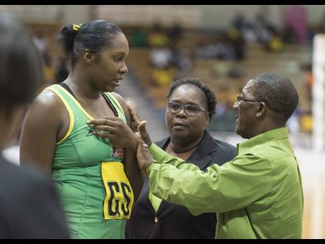 Former Sunshine Girls assistant coach Winston Nevers (right) speaks with goal shooter Jhaniele Fowler (left) while looking on is former head coach Marvette Anderson during a Lasco Sunshine Series match against the England Roses at the National Indoor Sports Centre on Saturday, October 13, 2018.