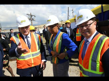 Energy Minister Fayval Williams participates in the commissioning of the Hybrid Energy Storage System at the Hunts Bay substation on Marcus Garvey Drive in Kingston on Wednesday. Flanking her are JPS President Emanuel DaRosa (left) and Il Jun Park, CEO of EWP.