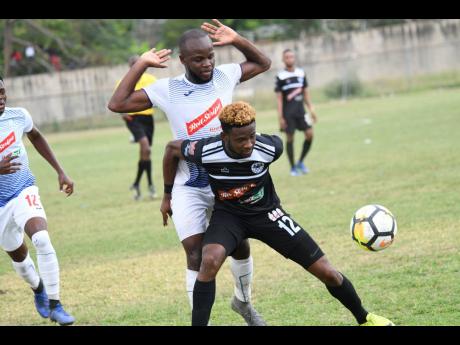 Javon East of Portmore United and Gadail Irving (front) of Cavalier battle for possession during a Red Stripe Premier League match at the Spanish Town Prison Oval on Sunday, February 10, 2019.