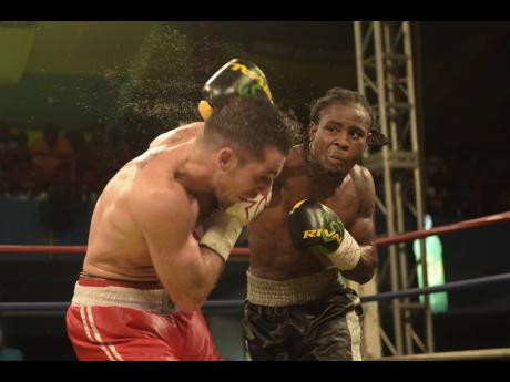 Jamaica’s Richard ‘Frog’ Holmes (right) delivers a heavy right to the head of Canadian Frank Cotroni during their Wray & Nephew Contender Boxing Series quarter-final match at the Chinese Benevolent Association Auditorium on Wednesday, June 14, 2017.