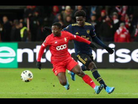 Arsenal’s Bukayo Saka (right) vies for the ball with Standard Liege’s Collins Fai during their Europa League Group F match at the Maurice Dufrasne Stadium in Liege, Belgium, yesterday.