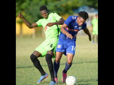 Mount Pleasant’s Suelae McCalla (right) jostles for possession of the ball with Molynes United’s Sergeni Frankson in their Red Stripe Premier League encounter at the Constant Spring field yesterday.
