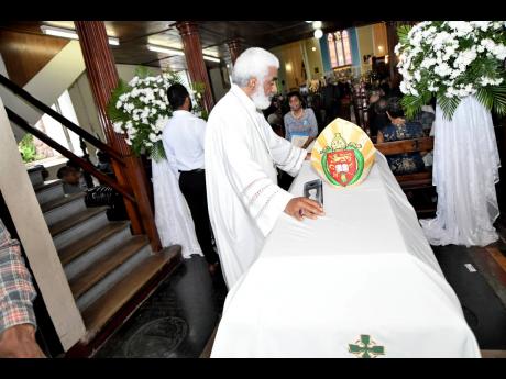 The Reverend Dr Robert Thompson pays his respects to the late Reverend Dr Alfred Reid at the mass of resurrection for the retired Bishop of Jamaica and the Cayman Islands at the Cathedral of St Jago de la Vega in Spanish Town, St Catherine, yesterday.