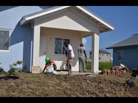A crew completes work on the yard of a housing unit at The Orchards in St Catherine. Prime Minister Andrew Holness says the Government will be seeking to invest heavily in addressing the need for housing in 2020. 