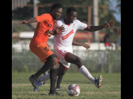 Tivoli Gardens’ Jermaine Johnson (left) duels with UWI’s Tejuarn Williams during their Red Stripe Premier League encounter at the Edward Seaga Complex yesterday.