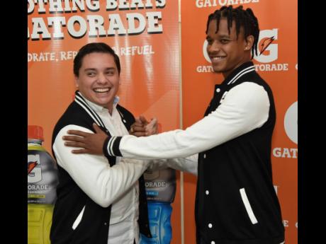 Peter-Lee Vassell (right) and Michael Castillo, commercial director, Gatorade, shake hands after Vassell signed a contract for a two-year deal to be the brand ambassador for Gatorade during a signing ceremony at Pepi-Cola Jamaica offices in Kingston on Wednesday, December 18, 2019.