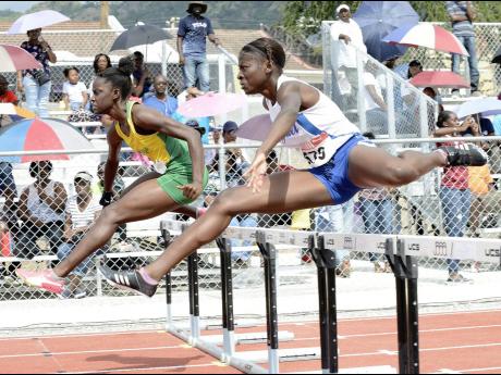 Rosalee Cooper (left) of St Jago High and Hydel High’s Taffara Rose battling for top spot in Heat One of the Class One girls’ 100 metres hurdles at the Purewater/JC/R. Danny Williams Invitational Development meet at Jamaica College on Saturday, January 5, 2019. Cooper won in 14.32 seconds.