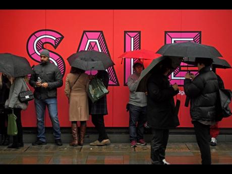 AP 
Customers queue in the rain ahead of the Selfridges sales in London on Thursday, December 26, 2019, as the traditional post-Christmas sales begin. 