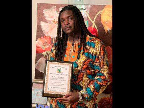 Richie Innocent holding the Certificate of Excellence he received at the Sarabita Masters Award in New York.