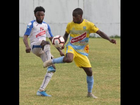 Waterhouse midfielder Tremaine Stewart (right) takes down the ball while being challenged by Portmore United’s Tevin Shaw during their Red Stripe Premier League game at the Spanish Town Prison Oval on Sunday, November 10, 2019.
