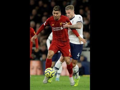Tottenham’s Toby Alderweireld (right) fights for the ball with Liverpool’s Roberto Firmino during the English Premier League match between Tottenham Hotspur and Liverpool at the Tottenham Hotspur Stadium in London, England, yesterday. Liverpool won 1-0.