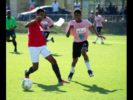 Real Mona’s Raphael Maxwell attempts to take the ball away from Samuel Shakes of Cavalier in their Alliance MoneyGram  KSAFA Under-17 
final played at the UWI/JFF Captain Horace Burrell Centre of Excellence at the University of the West Indies, Mona campus, on Saturday, July 13, 2019.