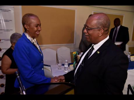 Minister of Science, Energy and Technology Fayval Williams is greeted by Chief Executive Officer, Passport Immigration and Citizenship Agency, Andrew Wynter, on Wednesday at the Terra Nova All-Suite Hotel in Kingston, at the launch of the new National Public Key Infrastructure project.
