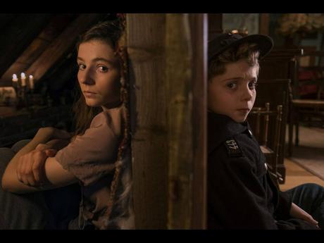 Jojo’s (Roman Griffin Davis) life turns upside down when he finds out his mother is hiding a young Jewish girl (Thomasin McKenzie) in ‘Jojo Rabbit’.
