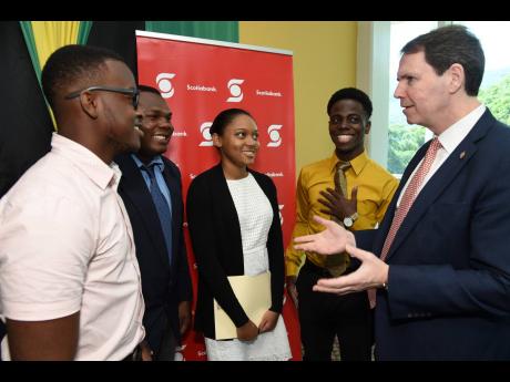 Brendan King (right), senior vice-president of international banking, Scotiabank, congratulates students of The University of the West Indies who were awarded scholarships. Each scholarship is valued at CDN$3,000 from funding of CDN$75,000 annually. The recipients are (from left) Joshua Page, Mouyton May, Jodi Moore and Tajay Henry. The disbursement was made at The UWI’s Regional Headquarters in Mona, St Andrew, on Tuesday.