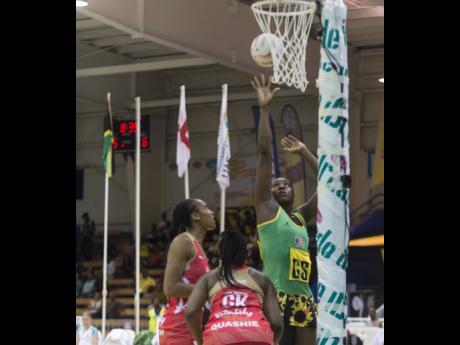 Jamaica captain and goalshooter Jhaniele Fowler (right) takes a shot while England goalkeeper Razia Quashie (centre) and goal defence Layla Guscoth look on during a three-match series at the National Indoor Sports Centre in Kingston on Saturday, October 13, 2018.