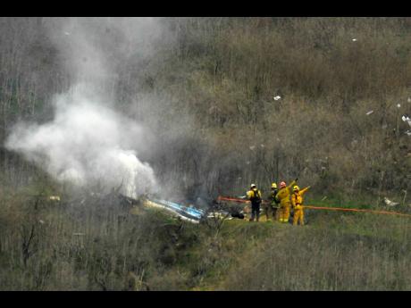 Firefighters work the scene of a helicopter crash where former NBA star Kobe Bryant died in Calabasas, California on Sunday Morning.