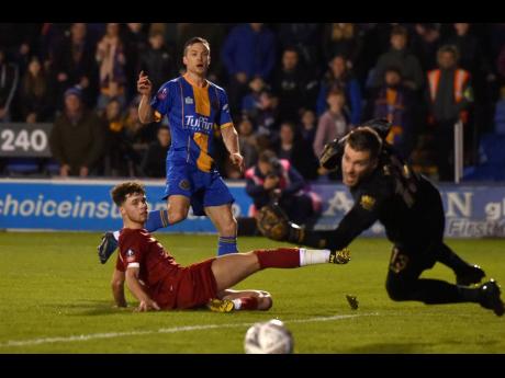 Liverpool’s Neco Williams (left) tries to block a shot from Shrewsbury’s Shaun Whalley (centre) during their English FA Cup fourth-round match at the Montgomery Waters Meadow in Shrewsbury, England, yesterday.