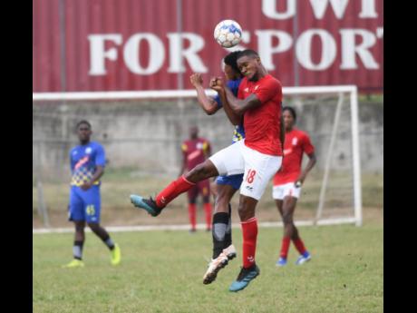 Molynes United’s Nicholas Nelson (left) goes up for a header with UWI’s Sheldon McKoy in their Red Stripe Premier League encounter at the UWI Mona Bowl yesterday.