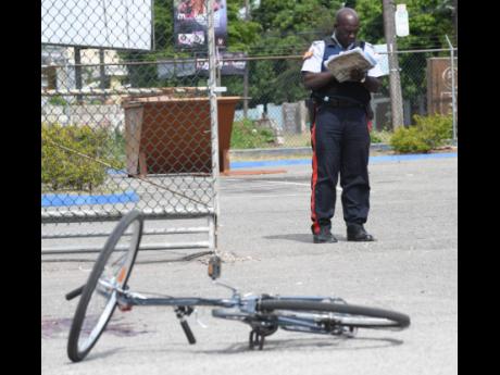 A policeman records notes at the scene of a murder near the entrance to the Nannyville Health Centre on Tuesday.