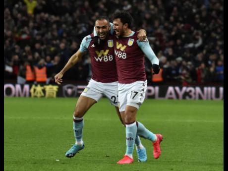 Aston Villa’s Trezeguet (right) celebrates with teammate Ahmed Elmohamady after scoring his side’s second goal during the English League Cup semi-final second leg match against Leicester City at Villa Park yesterday.