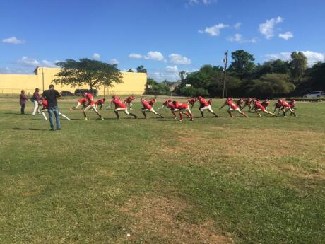 Newell High School’s tackle football players engage in warm-up drills recently, ahead of their upcoming National Gridiron Championship game against Munro College at the UWI Mona Bowl tomorrow.