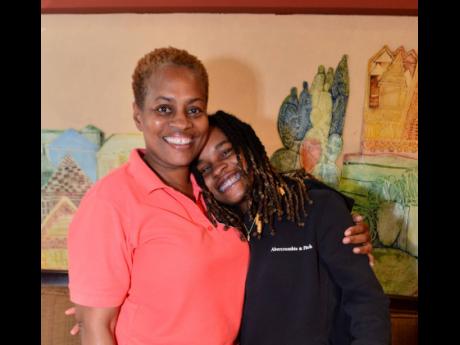 Reggae singer Koffee is embraced by mom Jo-Anne Williams during a press briefing at the Norman Manley International Airport on Monday. Koffee won the Grammy for Best Reggae Album just over a week ago. 