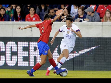 Costa Rica defender Maria Coto (left) and United States forward Christen Press battle for the ball during the first half of a CONCACAF women’s Olympic qualifying match in Houston on Monday. United States 
won 6-0.
