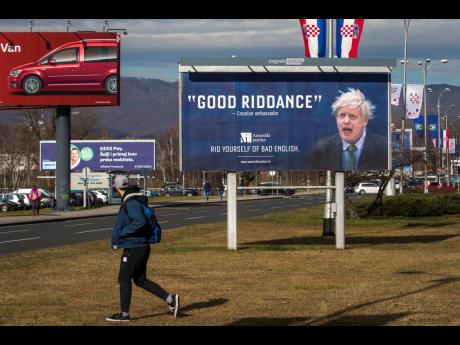 An advertising billboard for an English language school depicts Britain's prime minister Boris Johnson, in Zagreb, Croatia, Thursday, February 6, 2020.  The billboard by an English language Croatian school makes fun of a Croatian official who erroneously used the “good riddance” phrase when Britain left the EU at the end of January.