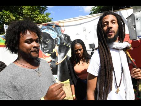 Artist Paige Taylor (left) chats with Julian Marley following the unveiling of the ‘Redemption’ mural at Bob Marley Museum last Thursday. Monique Kidd, Taylor’s assistant, is in the background.